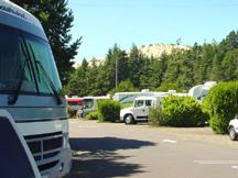 Our motorhome in RV park with sand dune visible above trees in background